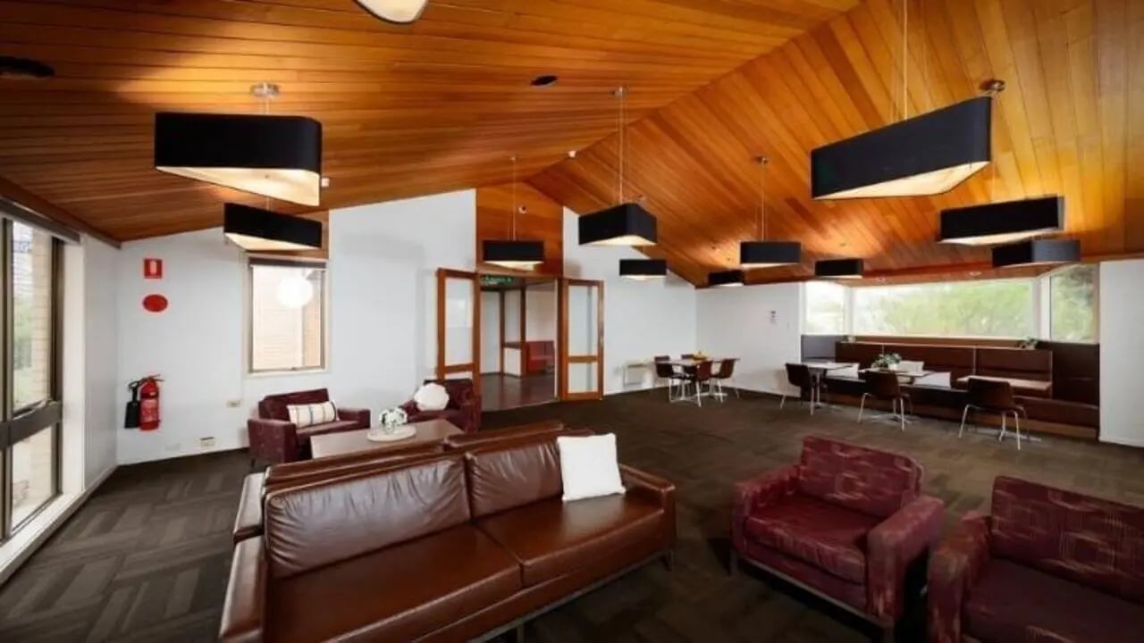 Brown sofas chairs tables and dining area lounge at UniLodge @ UC - Campus West & Guginya in Canberra Student Accommodation