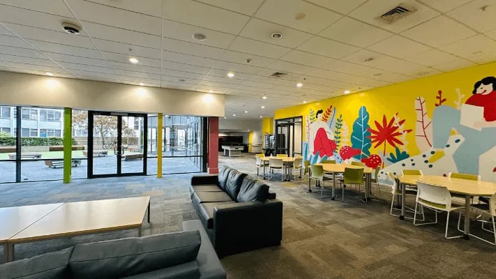 Couches tables and vibrant mural living room at Wellesley Apartments in Auckland Student Accommodation