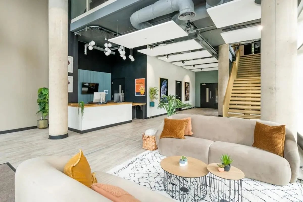 Lobby with reception desks sofas and stairs common area at Hillfort House in Brighton Student Accommodation