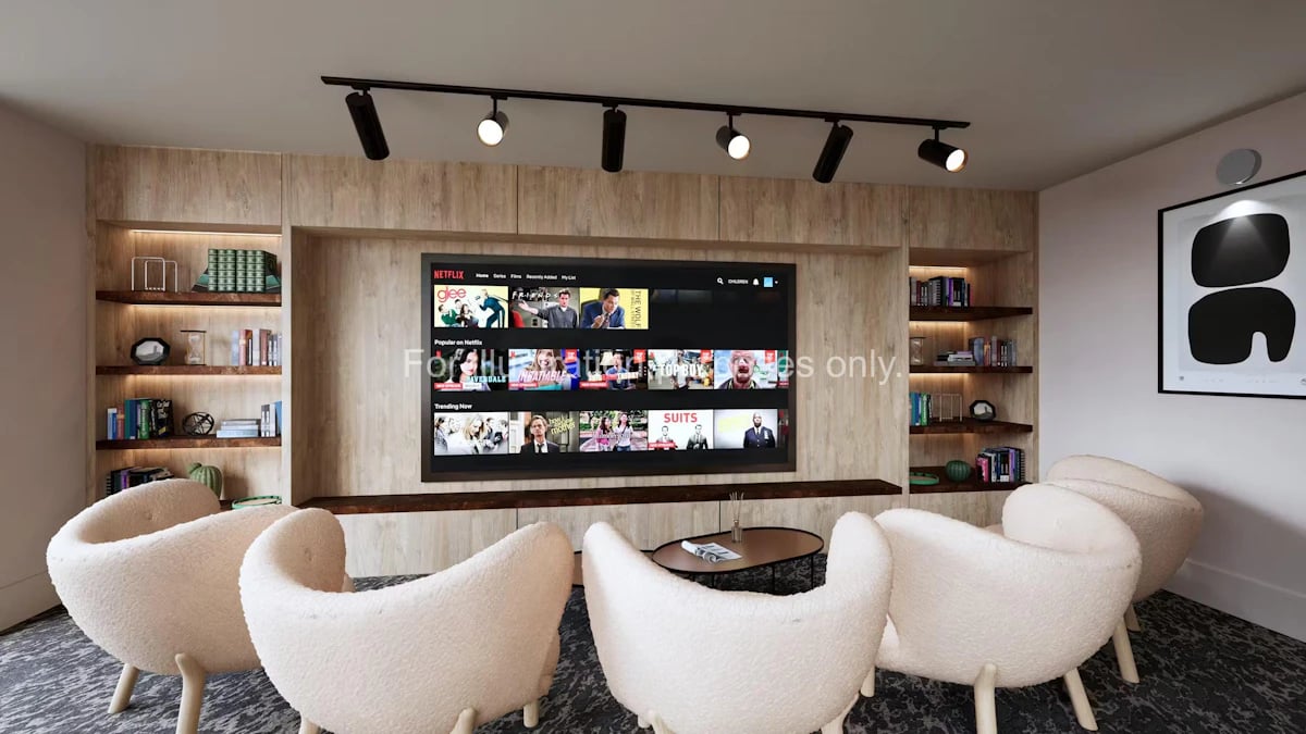Comfortable chairs by TV and bookshelves Living room at The Fabric Works in Leeds Student Accommodation