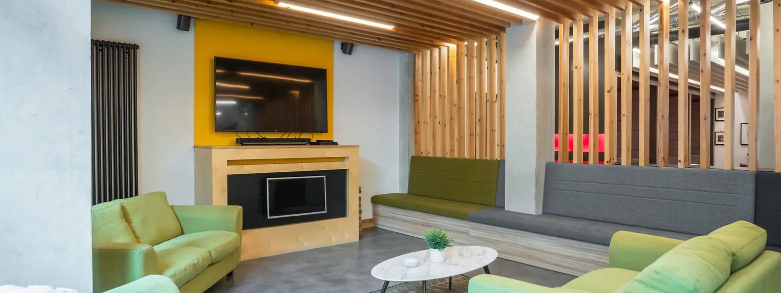 Green and grey sofas television and coffee table lounge area at Oxford House - Newcastle in Newcastle Upon Tyne Student Accommodation