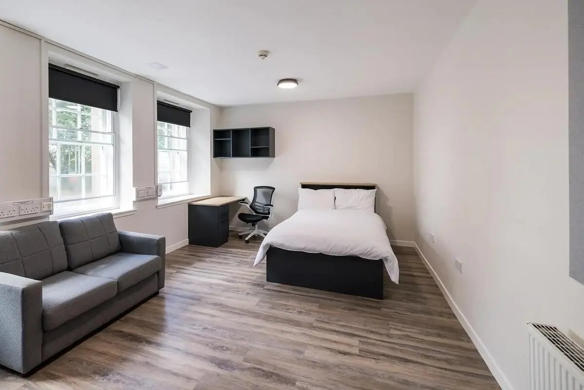 Grey sofa bed desk chair shelving bedroom living room at Lyon Street Terrace in Dundee Student Accommodation