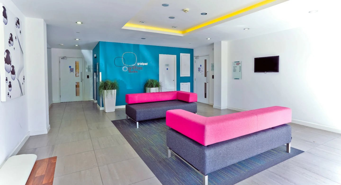 Modern seating area with bright pink couches lounge at Griffon Studios in London Student Accommodation
