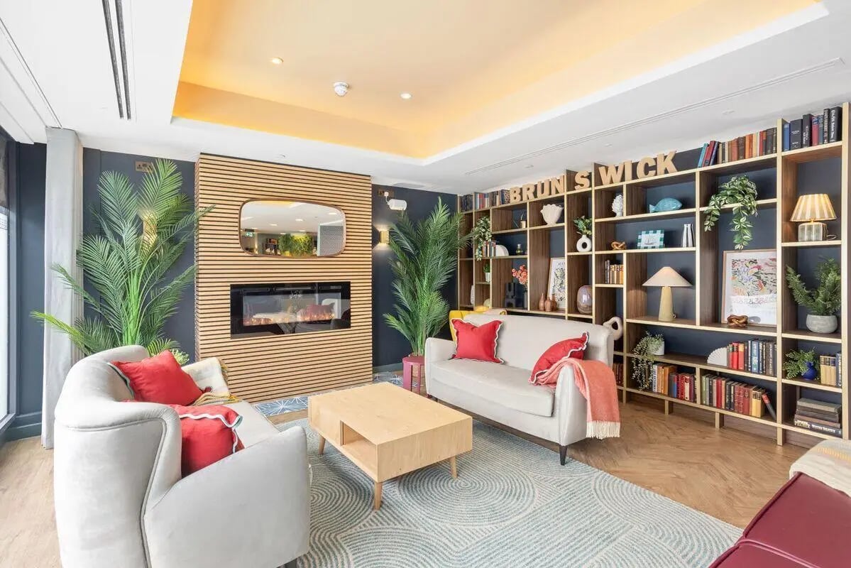 Modern living room with sofas fireplace and bookshelf living room at Brunswick Apartments in Southampton Student Accommodation