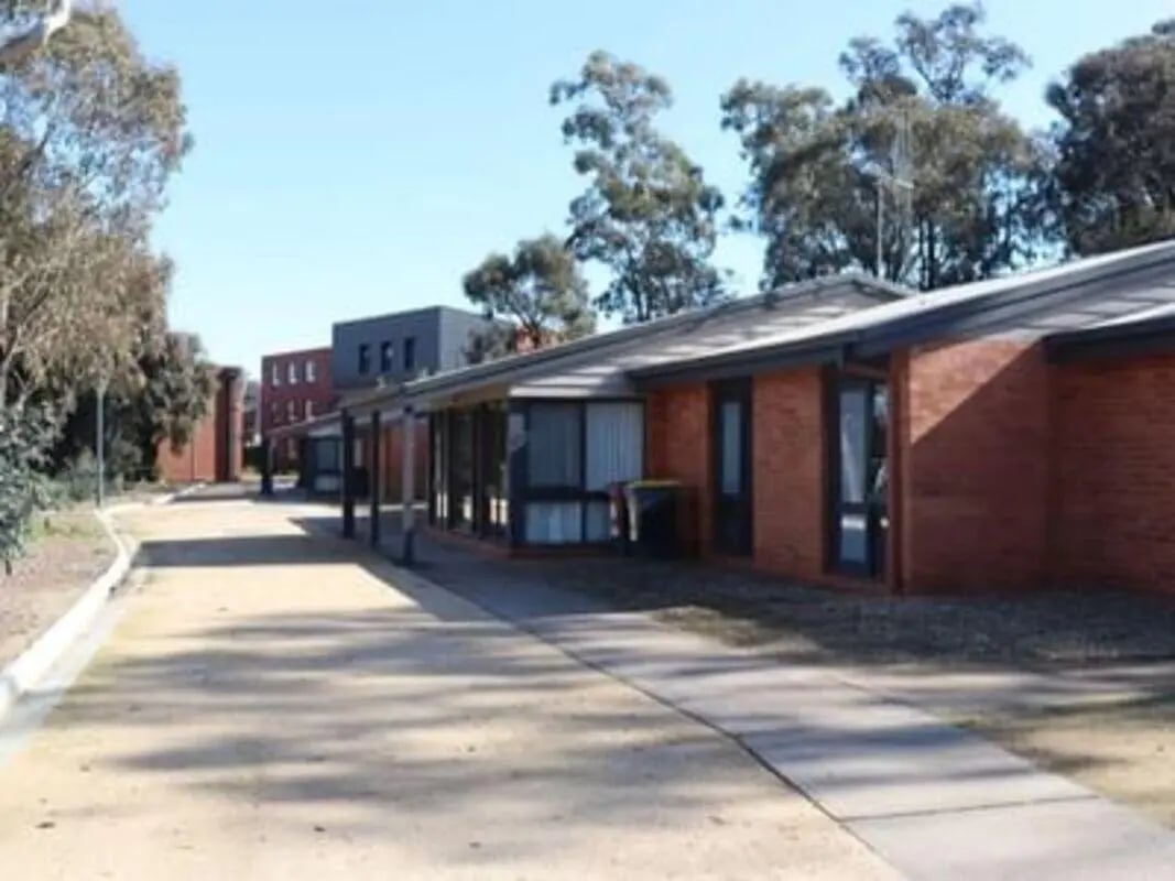 Red brick accommodation buildings with covered walkway exterior at La Trobe University - Terraces in Melbourne Student Accommodation