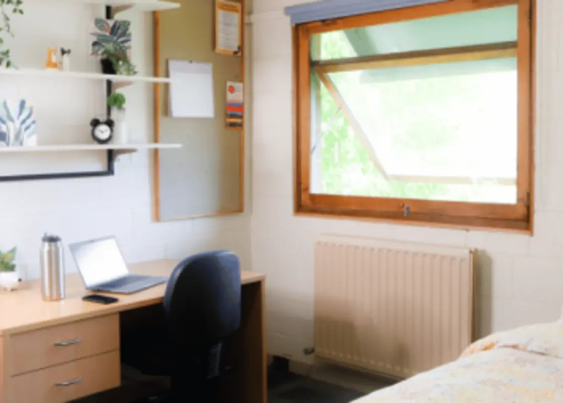 Desk laptop chair shelves plants radiator bedroom at La Trobe University - Units in Melbourne Student Accommodation