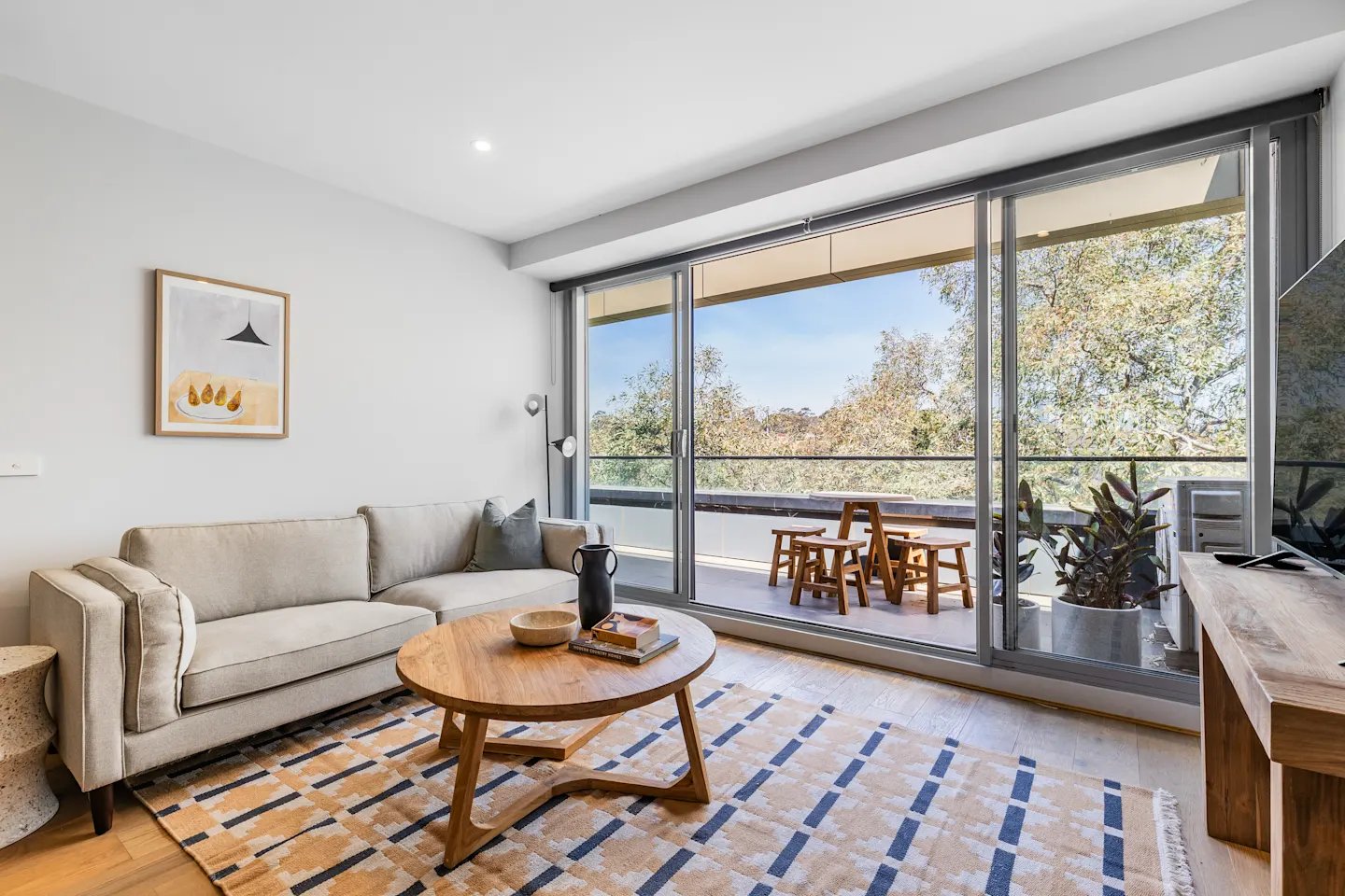 Sofa coffee table rug artwork balcony living room at UKO Royal Park in Melbourne Student Accommodation