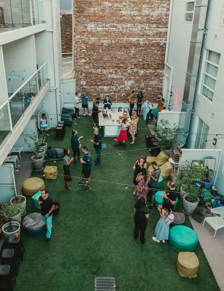 People socializing in courtyard outdoor seating area exterior at UKO Stanmore in Sydney Student Accommodation