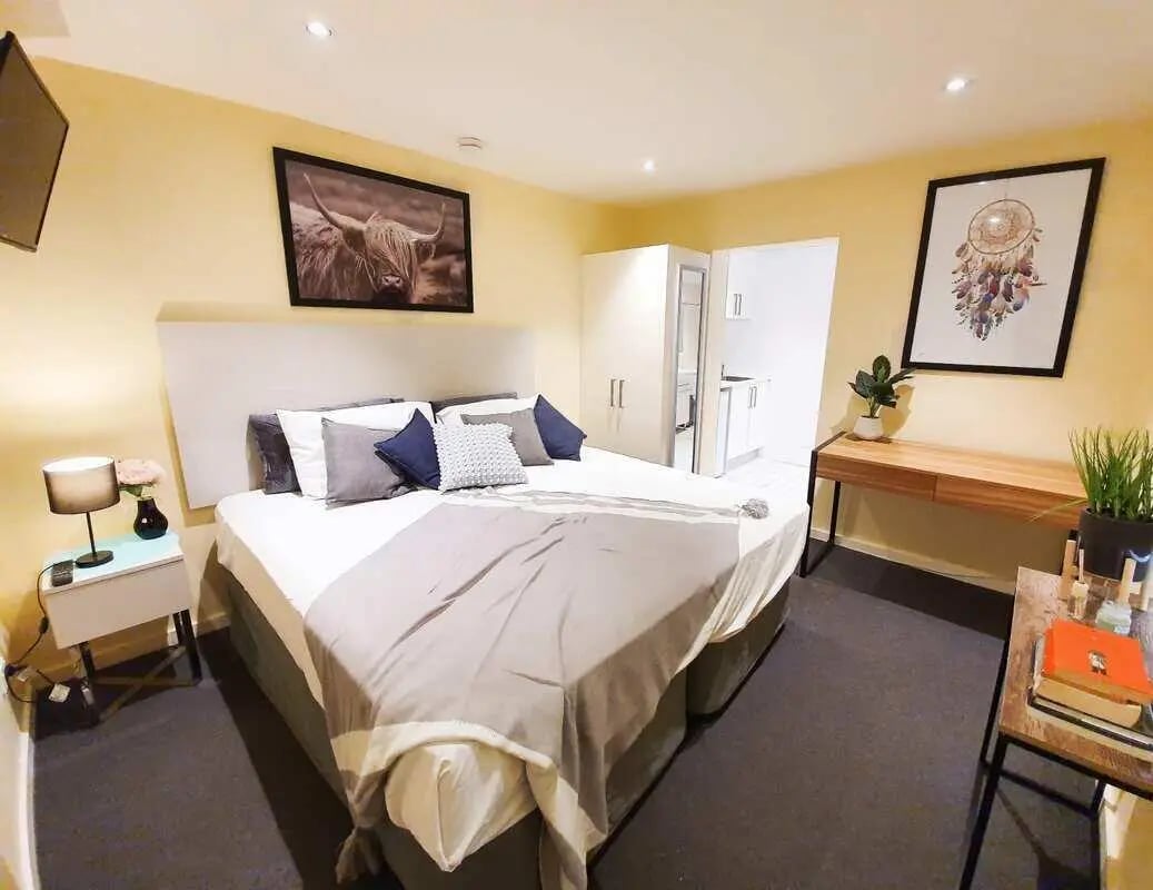 Bed with pillows nightstand and desk bedroom at ume 142 Darlinghurst Village in Sydney Student Accommodation