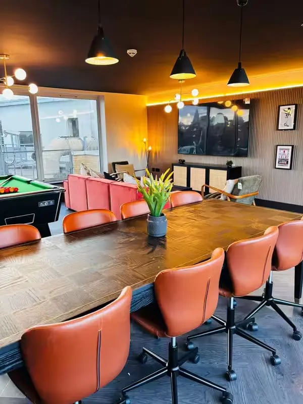 Large dining table leather chairs pool table common area at Camden Hawley Crescent in London Student Accommodation