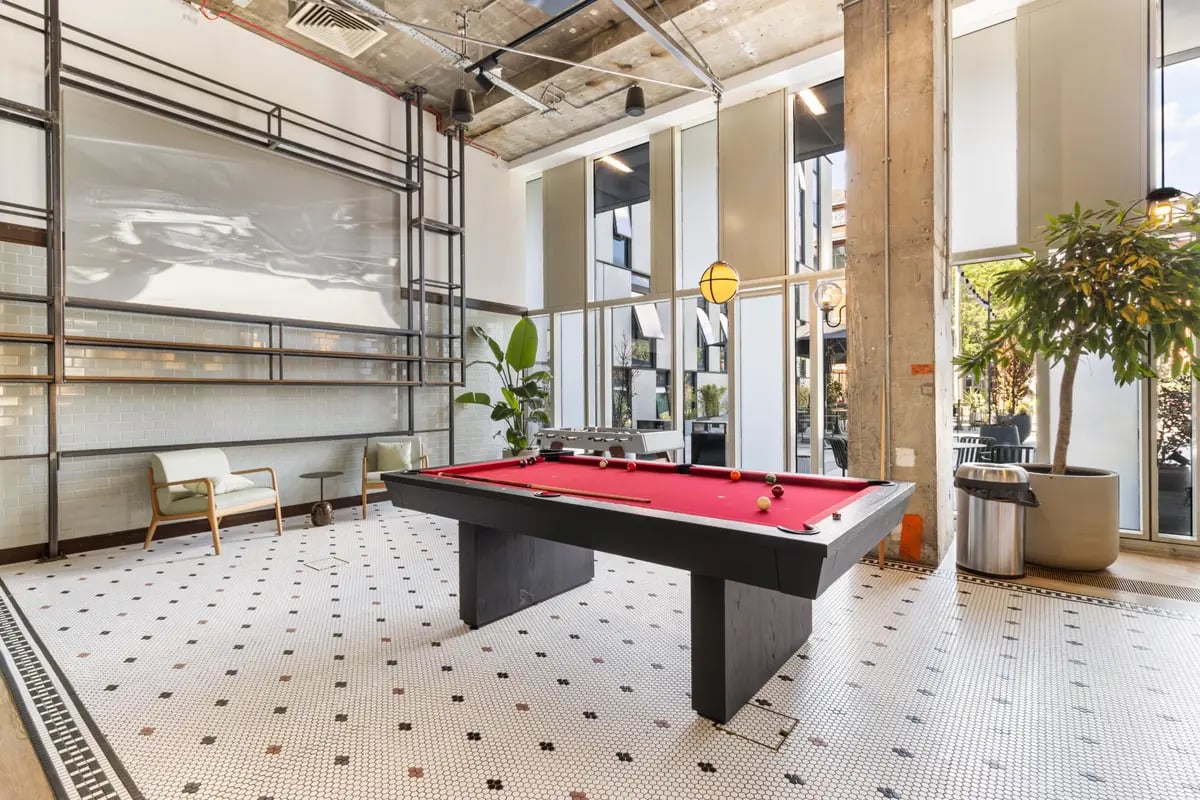 Pool table chairs plant and foosball table common area at Chapter Kings Cross in London Student Accommodation