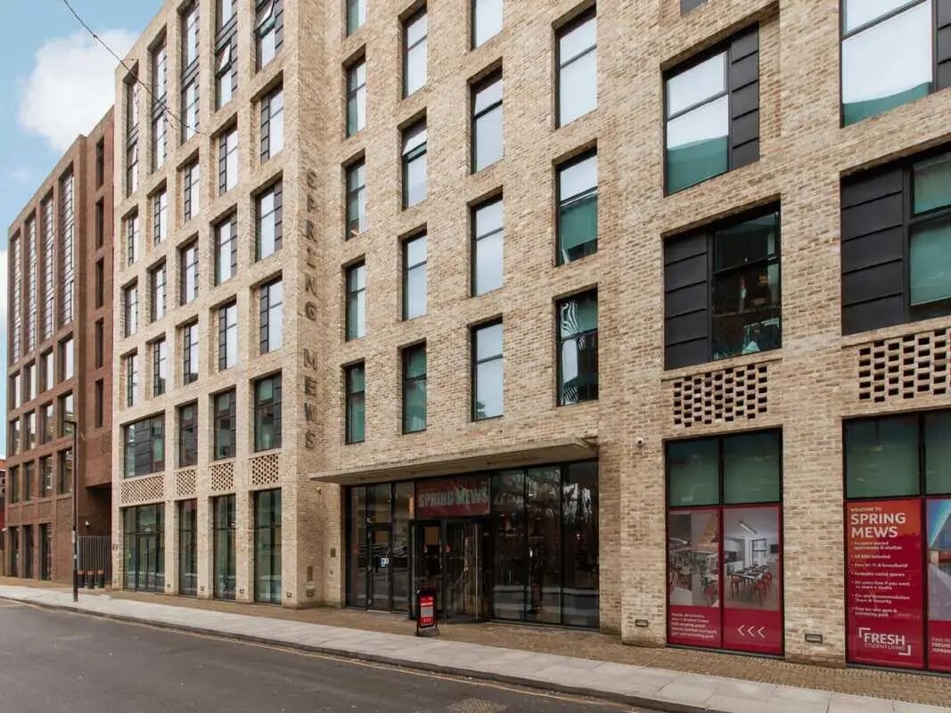 Brick building with windows and entrance exterior at Spring Mews in London Student Accommodation