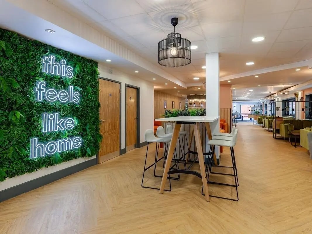 Neon sign living room with high table and chairs at The Forge in Sheffield Student Accommodation