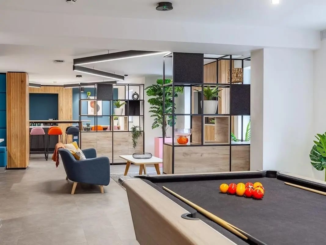 Pool table armchairs bar and shelving unit common area at Devonshire Courtyard in Sheffield Student Accommodation
