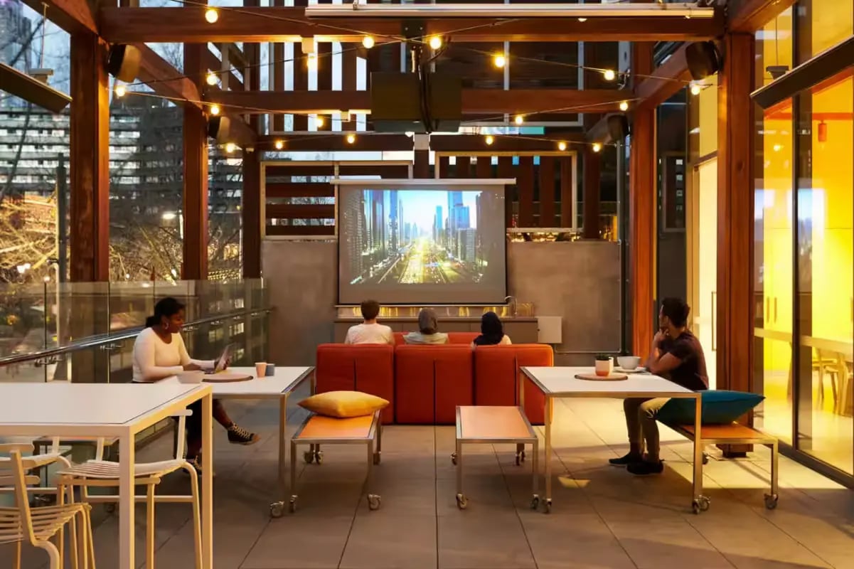 People watching movie on sofa with tables living room at Scape Swanston in Melbourne Student Accommodation