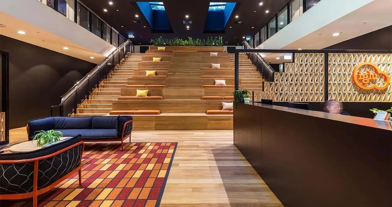 Modern reception area with tiered seating and sofas common area at Iglu Central Park in Sydney Student Accommodation
