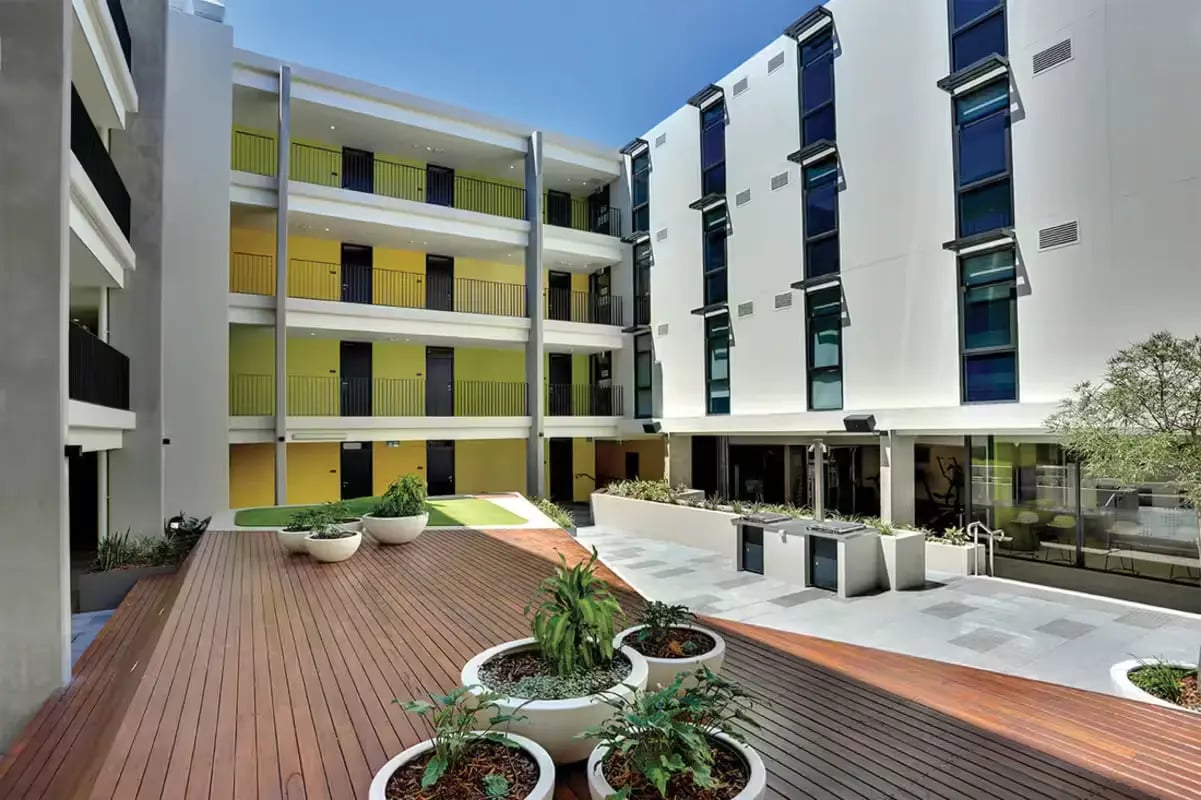Modern student housing courtyard with decking and plants exterior at Scape Glebe in Sydney Student Accommodation