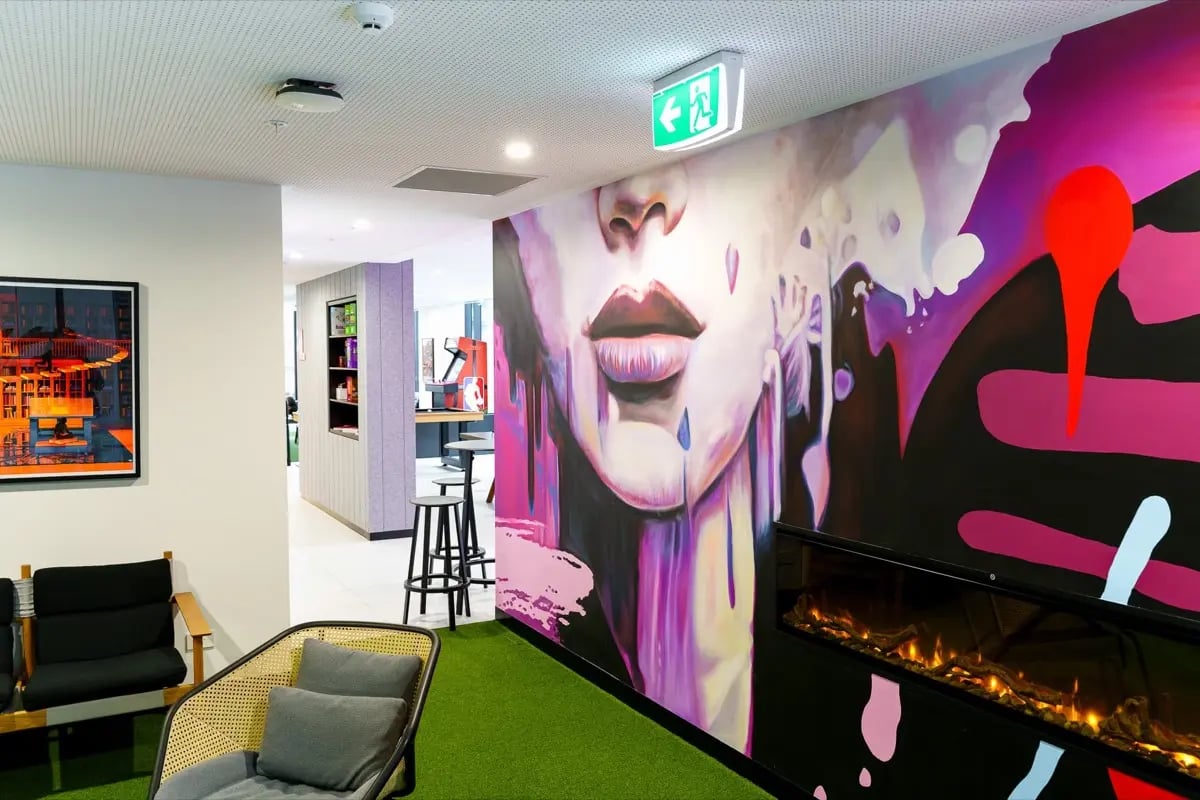 Artwork chairs fireplace artificial turf living area at The Switch Melbourne Victoria Market in Melbourne Student Accommodation