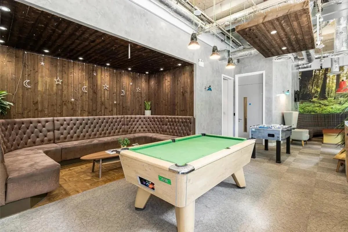Pool table foosball table and tufted sofa common area at Chapter Islington in London Student Accommodation
