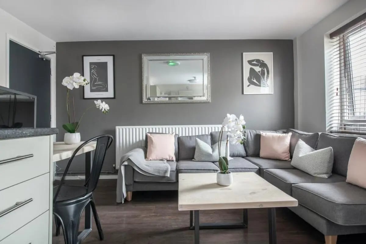 Gray sectional sofa with pink cushions coffee table living room at 4 Rob Roy House in Nottingham Student Accommodation