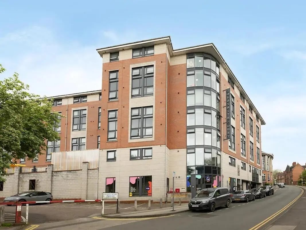 Brick building with many windows and cars Exterior at Yugo Goldsmith Court in Nottingham Student Accommodation