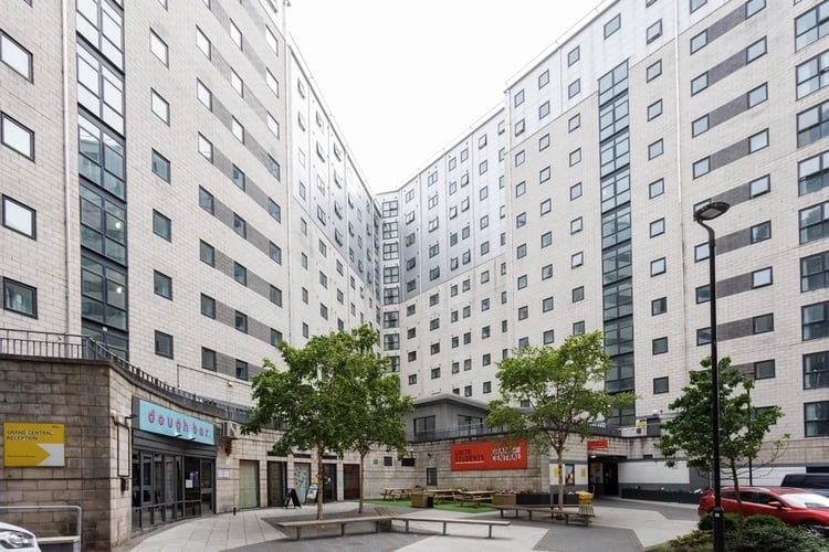 Courtyard with buildings benches trees exterior at Grand Central in Liverpool Student Accommodation