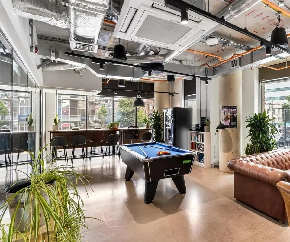 Pool table with chairs and sofa common area at Chapter Highbury II in London Student Accommodation