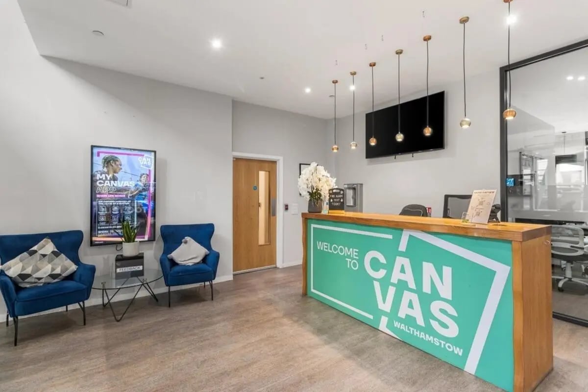 Reception desk with chairs and artwork Lobby at Canvas Walthamstow in London Student Accommodation