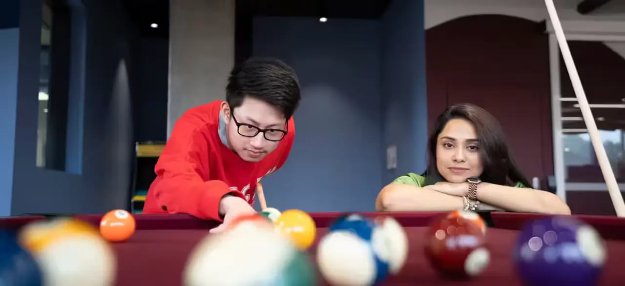 Two people playing pool table game room at Scape Lachlan in Sydney Student Accommodation