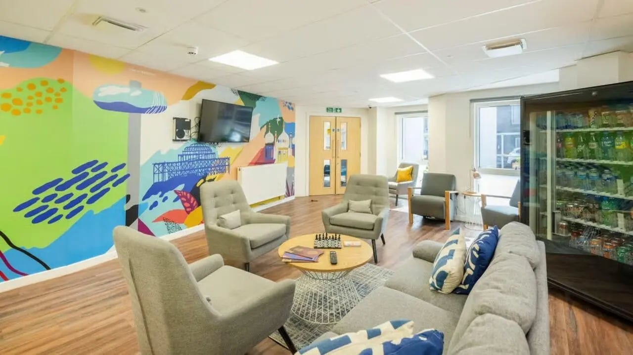 Sofa armchairs table TV vending machine living room at Hollingbury House in Brighton Student Accommodation