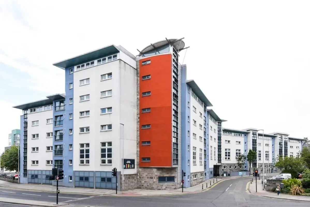 Modern student accommodation building exterior with blue and orange accents. Exterior at Mealmarket Exchange in Aberdeen Student Accommodation