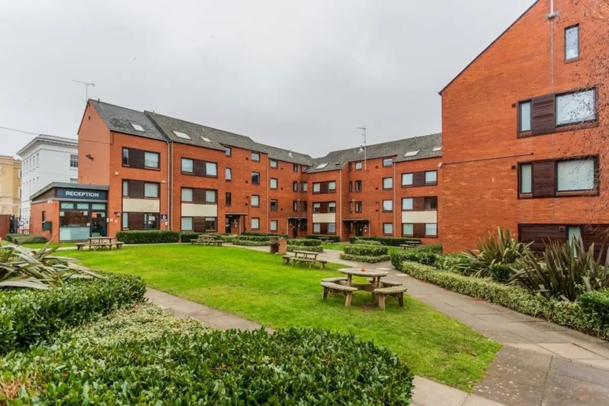Brick buildings with reception and picnic tables exterior at Regents Court in Leicester Student Accommodation