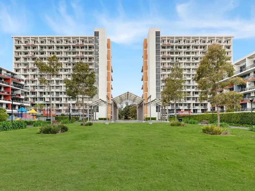 Apartment buildings with grass and playground exterior at Belong Waterloo in Sydney Student Accommodation