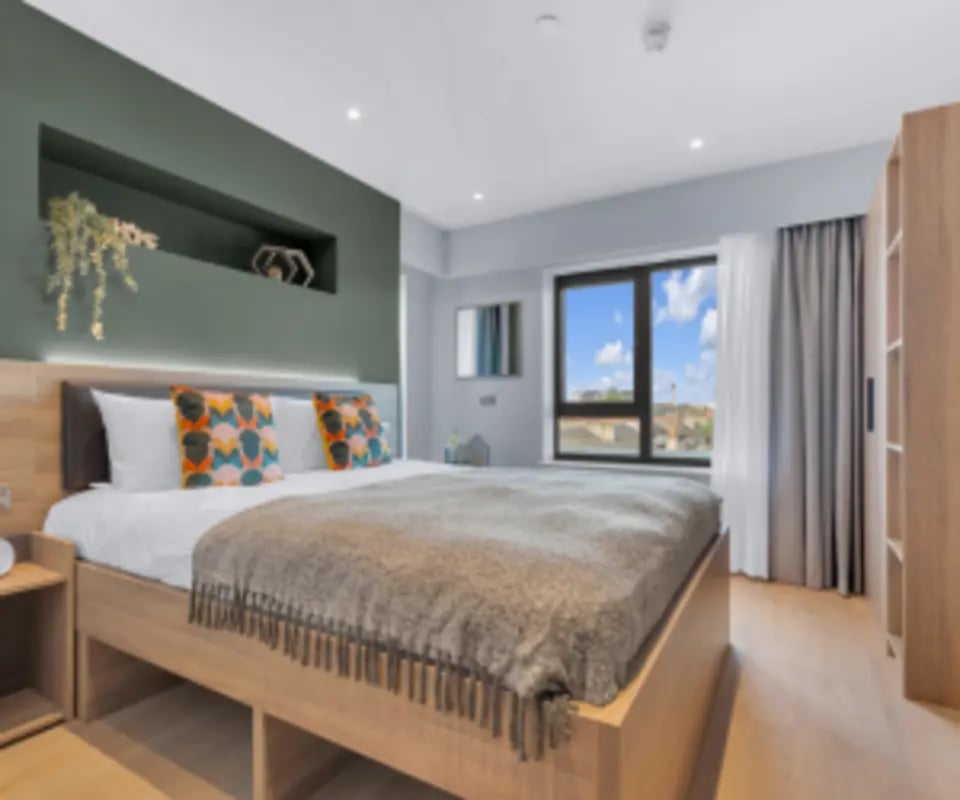 Bed with decorative pillows and wardrobe bedroom at Iconinc The Bonnie in Glasgow Student Accommodation