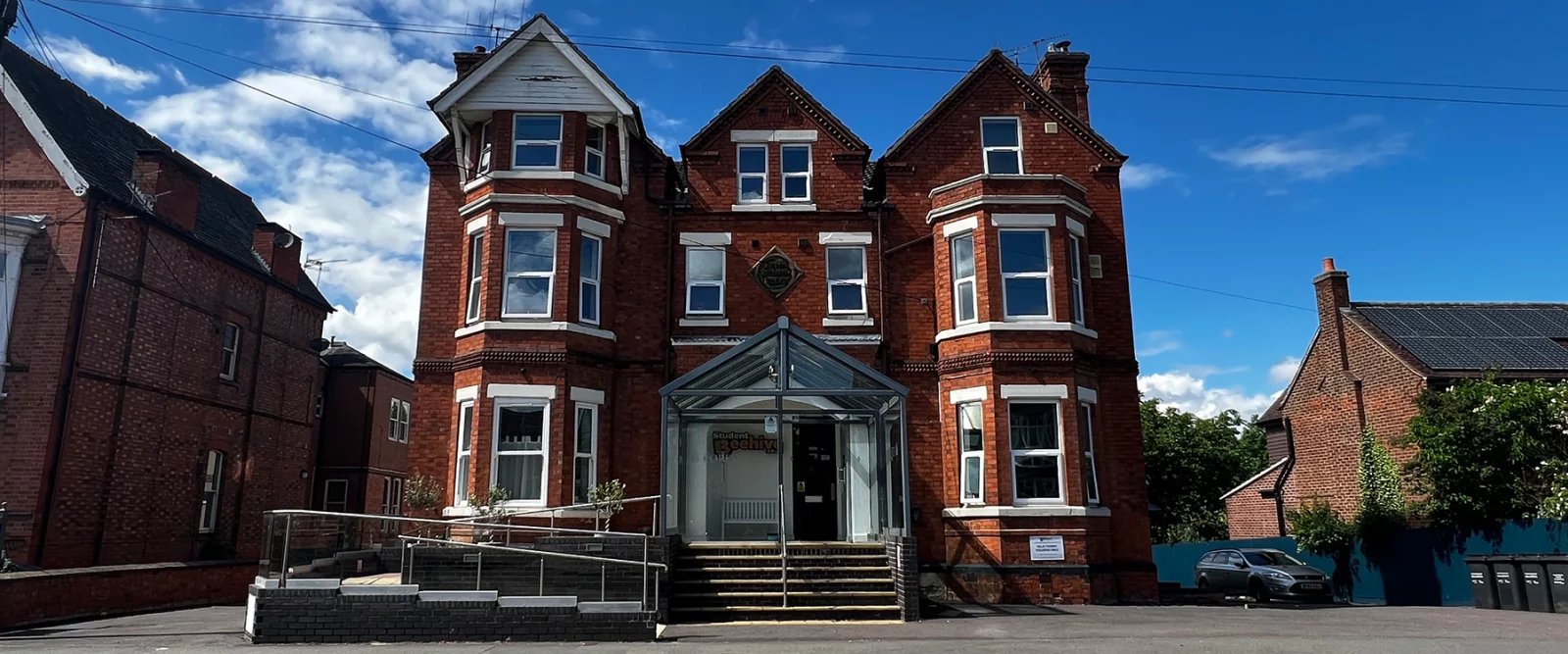 Brick building with bay windows and glass entrance exterior at Forest Rise in Loughborough Student Accommodation
