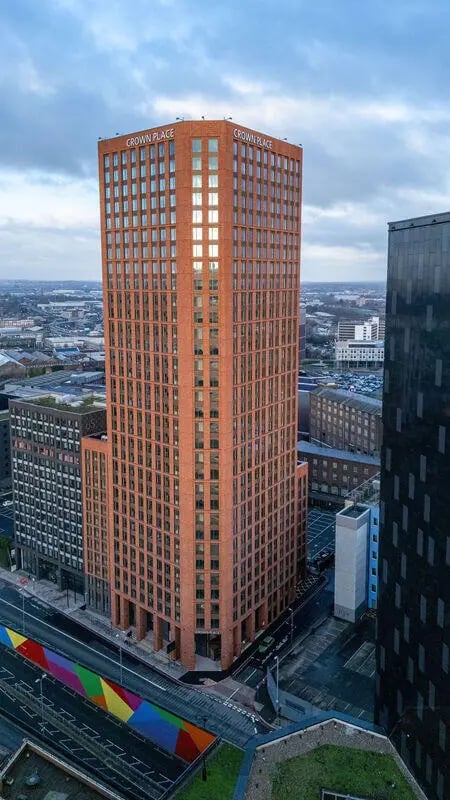 Tall brick building with Crown Place sign exterior at Yugo Crown Place in Birmingham Student Accommodation