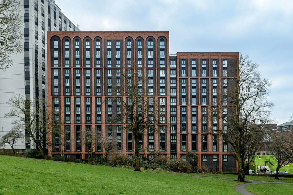 Brick buildings many windows green lawn exterior at True Nottingham in Nottingham Student Accommodation