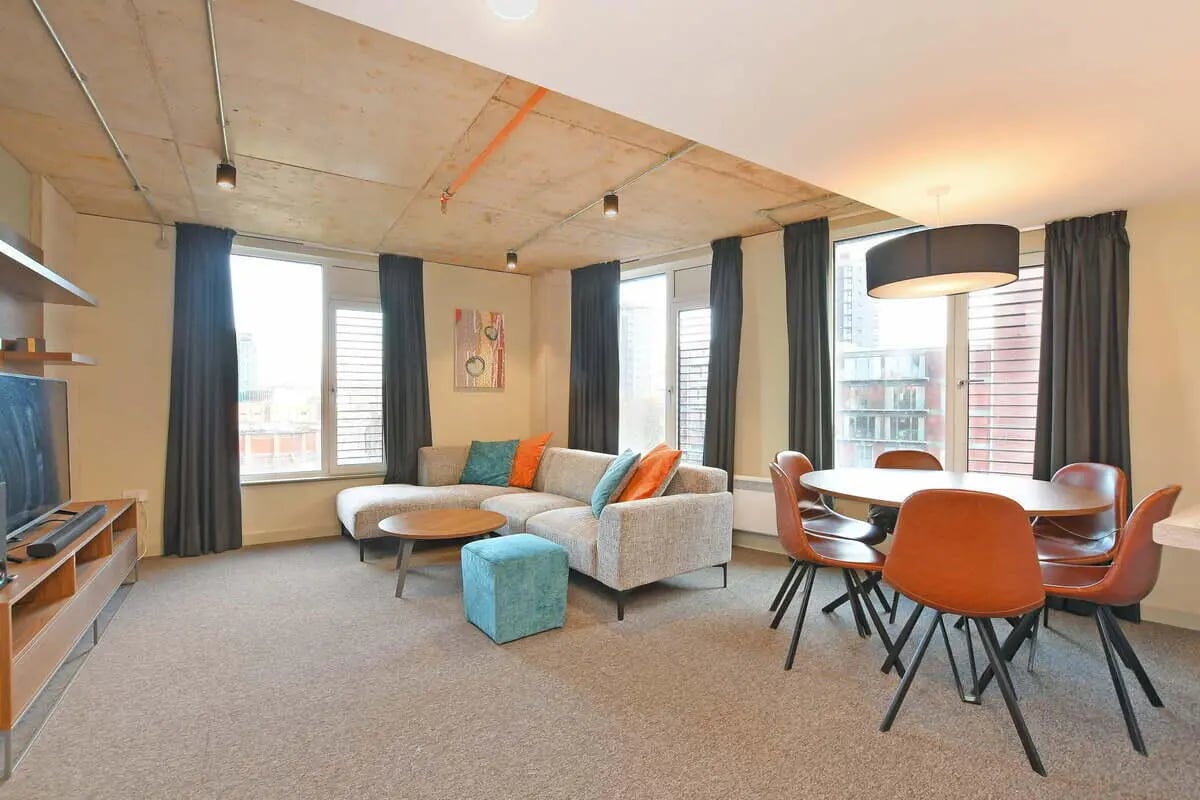 Sofa dining table chairs rug television living room at LIV Student Sheffield in Sheffield Student Accommodation