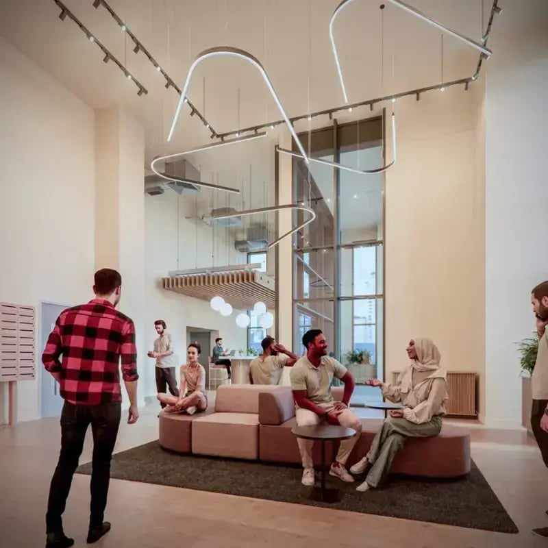 Modern lounge area with people and contemporary lighting at Hawthorne House in London Student Accommodation
