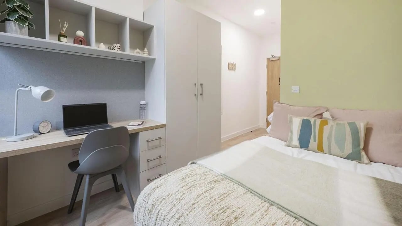Desk with laptop and shelves bedroom. at St Gabriels in Manchester Student Accommodation