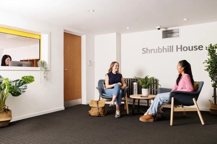 Two students chatting in seating area living room at Shrubhill House in Edinburgh Student Accommodation