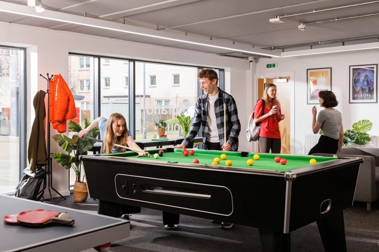 Students play pool in common room recreational area at Murano House in Edinburgh Student Accommodation