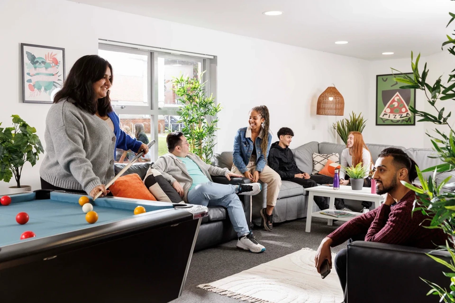 Students playing pool in common living room area at Mill Point in Manchester Student Accommodation