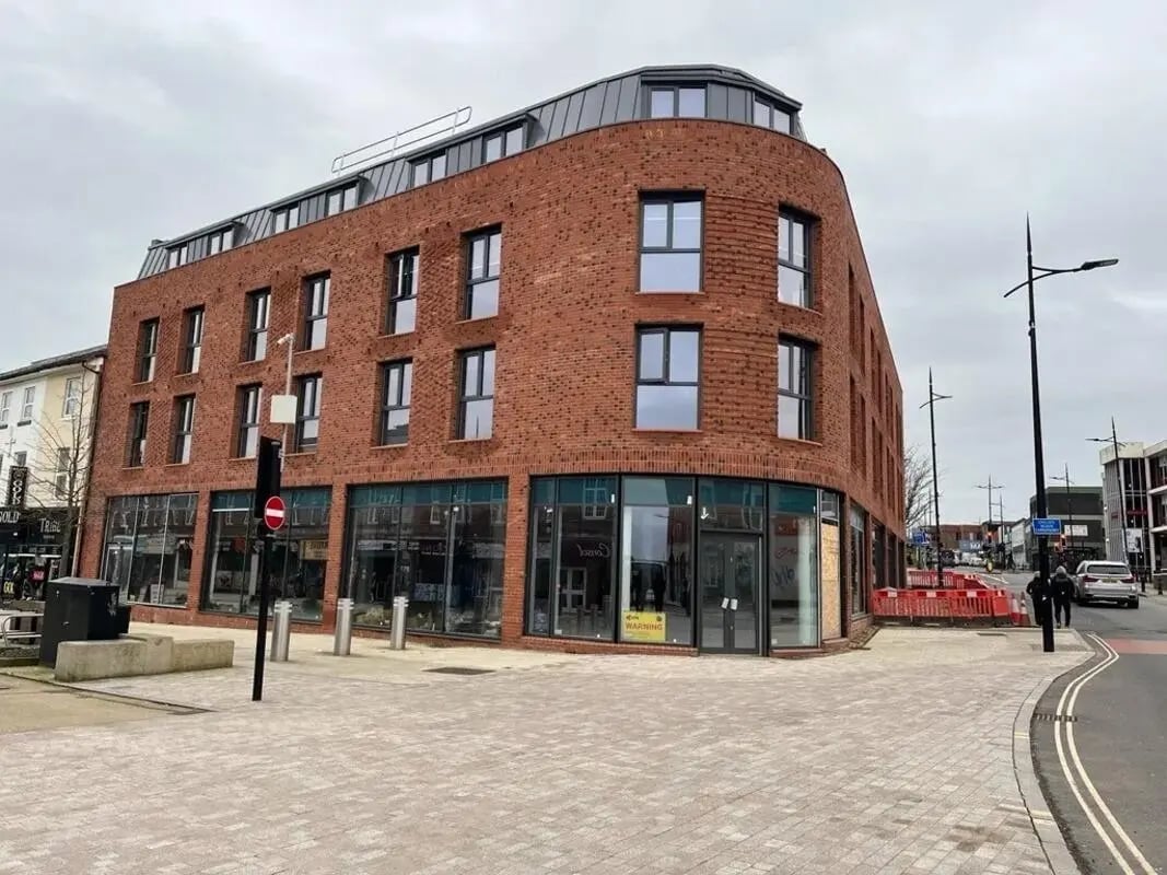 Red brick building with shops and windows exterior at Cleveland Apartments in Wolverhampton Student Accommodation