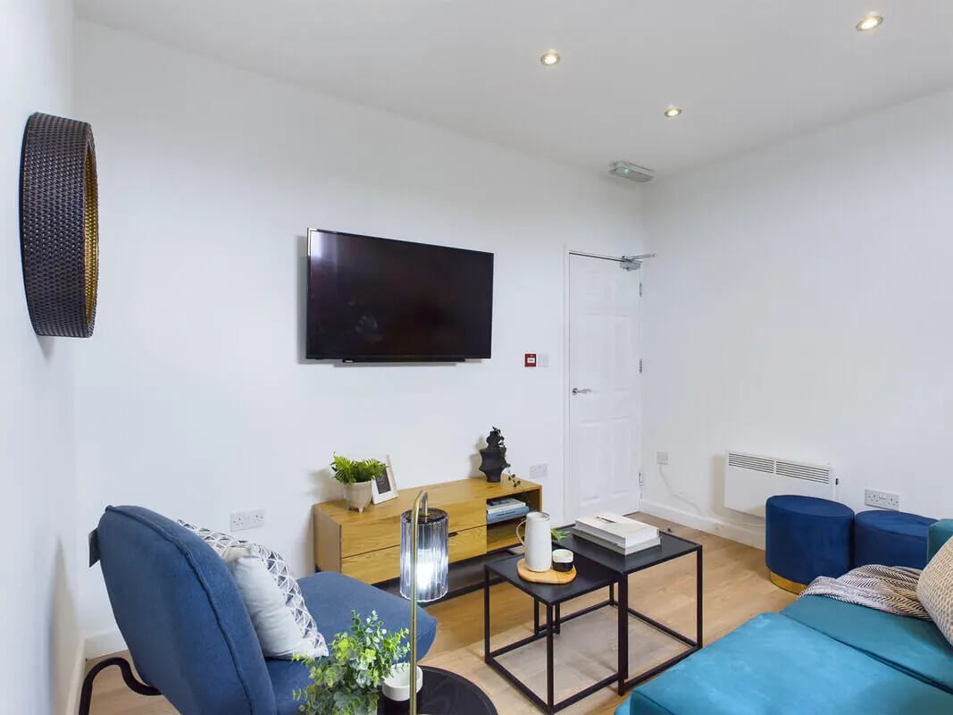 Blue sofa television wooden cabinet black coffee table living room at 5 Bedroom House at 408, Claremont Road in Manchester Student Accommodation