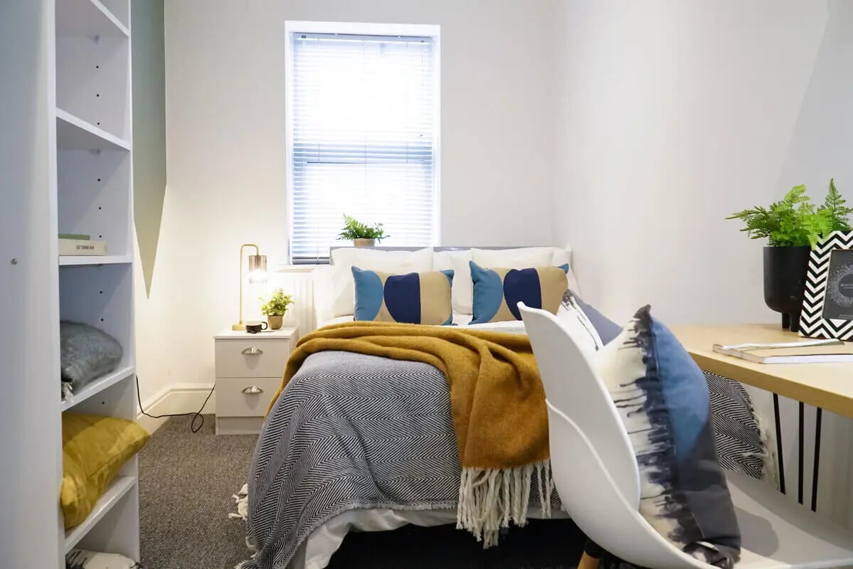 Bed with pillows blanket bedside table bedroom at 5 Bedroom House at 14, Driffield Street in Manchester Student Accommodation