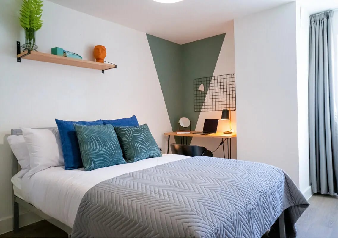 Bed desk plant shelf decorative head and pillows bedroom at 5 Bedroom House at 6, Maine Road in Manchester Student Accommodation