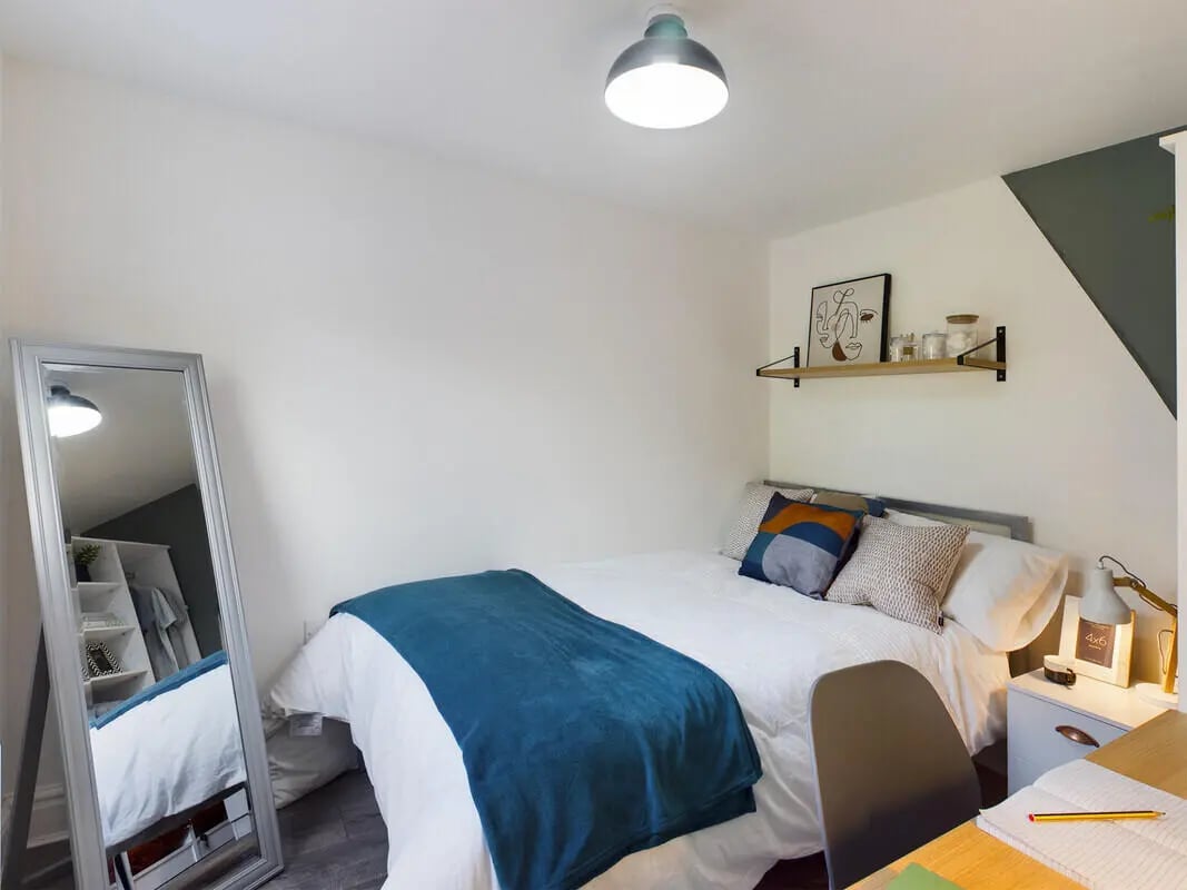Bed with blue throw full length mirror bedroom at 7 Bedroom House at 39, Ossory Street in Manchester Student Accommodation