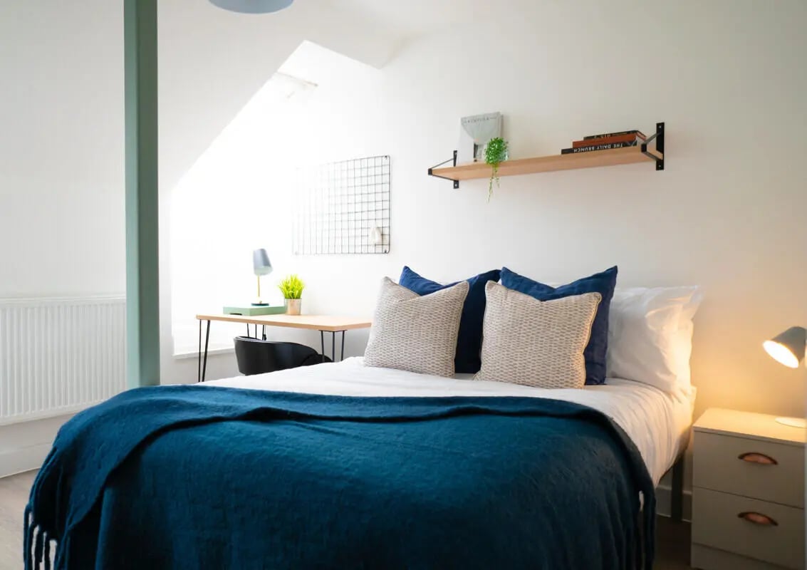 Bed with blue throw desk and lamp bedroom at 7 Bedroom House at 72, Ruskin Avenue in Manchester Student Accommodation