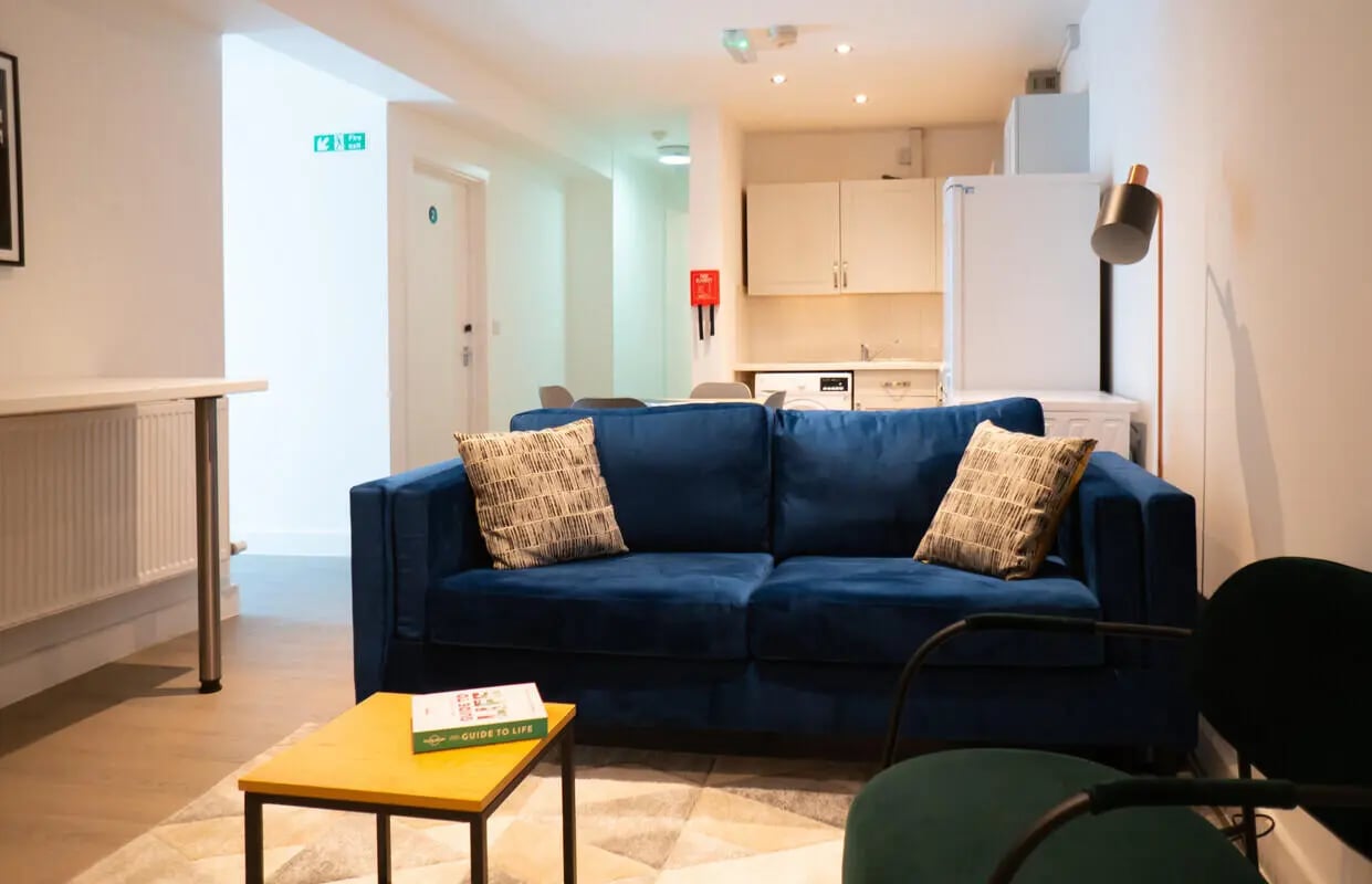 Blue sofa with cushions and coffee table living room at 3 Bedroom House at 68, St. Bees Close in Manchester Student Accommodation